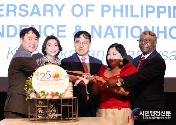 Deputy Foreign Minister Choi and Ambassador Dizon De Vega of the Philippines (center and fourth from left, respectively) cut celebration cakes with other members of the Seoul Diplomatic Corps. Ambassador Carlos Victor Boungou of the Republic of Gabon (dean of the Seoul Diplomatic Corps) joins the cake-cutting at right.