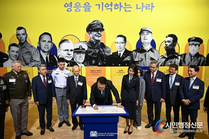 President Yoon Suk Yeol (middle) on June 25 signs the visitor log of an exhibition commemorating the 70th anniversary of the bilateral alliance with the U.S. at the National Museum of Korean Contemporary History in Seoul's Jongno-gu District