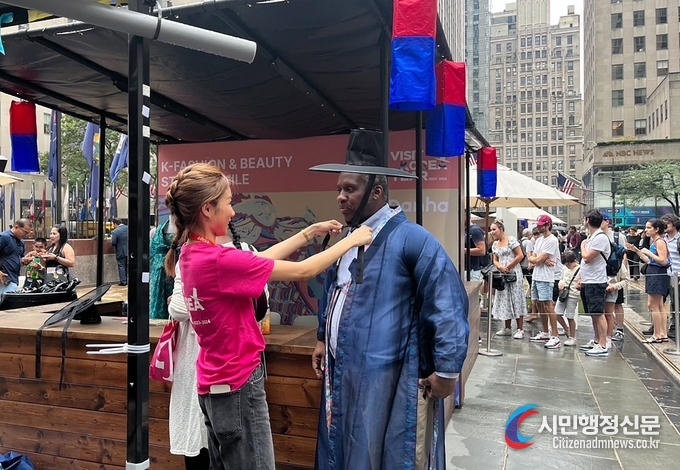 Visitors at the event try on Hanbok (traditional Korean clothes) at a promotional booth in NY's Rockefeller Center.