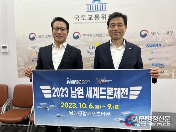 Namwon City Mayor Choi Kyung-sik (left) holds a placard heralding the 2023 Namwon World Drone Racing Competition.