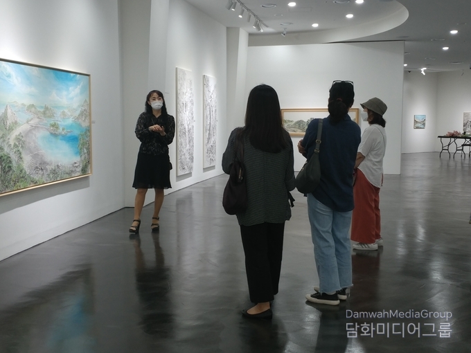 전시장을 찿은 손님들에게 설명을 하고있다. 