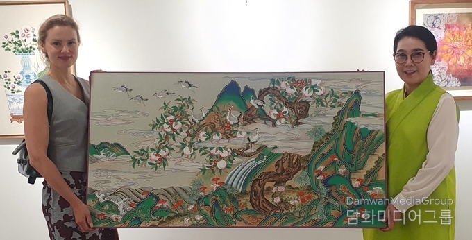  명지대 문화콘텐츠과 K민화 이미형 주임교사 벨라루스 대사부인에게 작품을 기증하고 있다. 