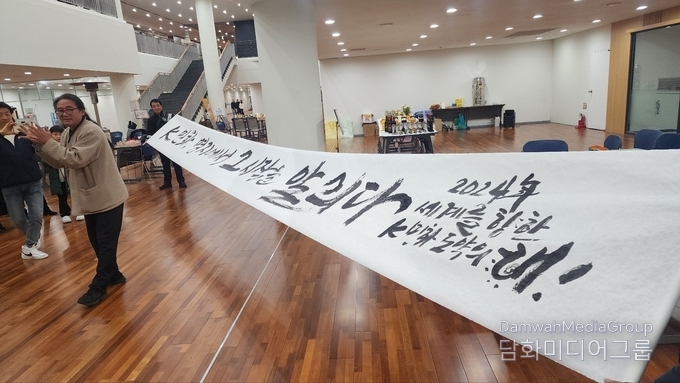 서예가 성파 황우연 작가가 K-민화 전시장을 찿아 K-민화, 명지에서 그 시작을 알리다. 퍼포먼스로 글을 쓰고 설명하고 있다. 