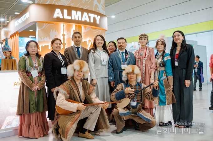 Ambassador of Kazakhstan Nurgali Arystanov takes a photo with the organizers of the Almaty booth at SITF.