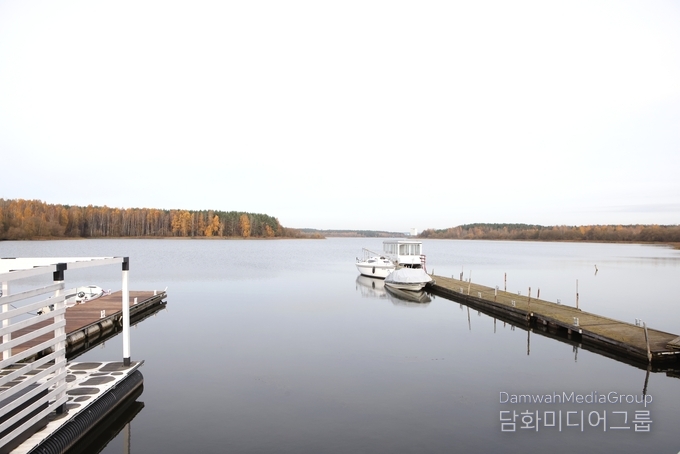  자슬라브스코예 호수(Zaslavskaye Reservoir, 일명 ‘민스크 바다’) 선착장의 전경. 잔잔한 수면 위로 정박한 요트와 흰색 유람선이 가을빛 단풍 숲과 어우러져 평화로운 풍경을 그린다. 도심에서 불과 5km 떨어진 이곳은 미니스크 시민들의 대표적 휴식처로, 자연과 고요가 공존하는 힐링 명소로 사랑받고 있다.(사진 최동호 국장)