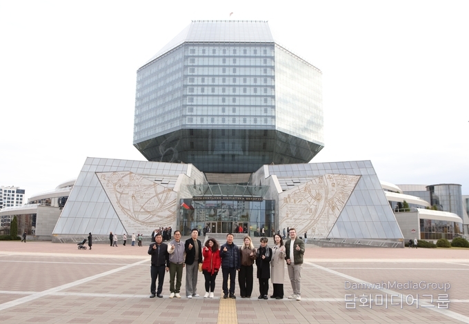 벨라루스 민스크의 상징적 건축물인 국립도서관(National Library of Belarus) 앞에서 한국 대표단이 기념촬영을 하고 있다. 팔각형 다이아몬드 형태의 독창적인 외관은 ‘지식의 보석’을 상징하며, 밤이 되면 건물 전체에 LED 조명이 켜져 붉고 푸른 빛으로 환하게 빛나 도시의 랜드마크로 변신한다. 지성의 상징이자 예술적 건축미를 겸비한 이곳은 민스크 시민들이 가장 자랑스러워하는 문화공간이다.( 사진-최동호 국장)