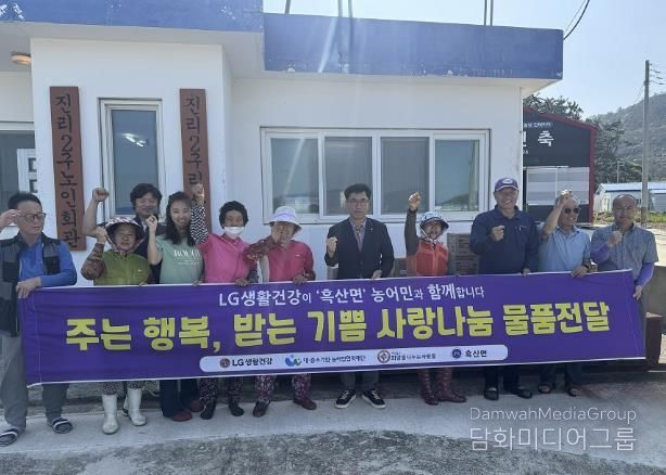 사)희망을나누는사람들 후원 물품과 흑산면 주민들이 함께 기념 촬영을 하고 있다.