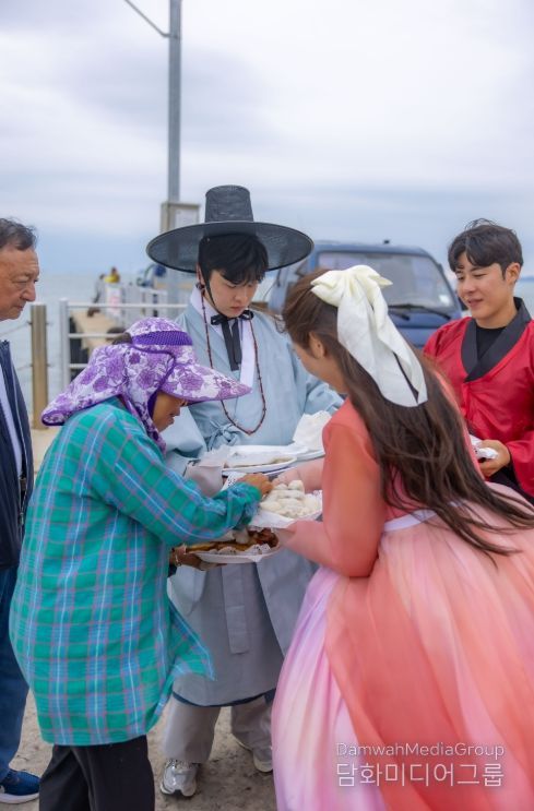 여행 참가자들이 섬 어르신들께 직접 만든 송편과 간식을 나눠드리고 있다