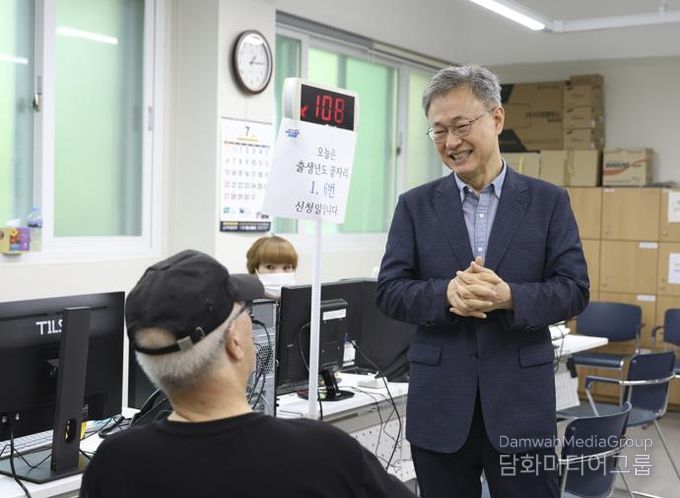 장인홍 구로구청장이 민생회복 소비쿠폰 신청 대기 중인 어르신과 인사를 나누고 있다.