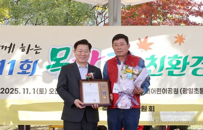 박승원 광명시장이 지난 1일 우리어린이공원에서 열린 ‘제11회 가족과 함께하는 목감천 친환경 축제’에 참석해 광명6동 주민자치회 위원에게 시장표창을 수여하고 기념사진을 촬영하고 있다.