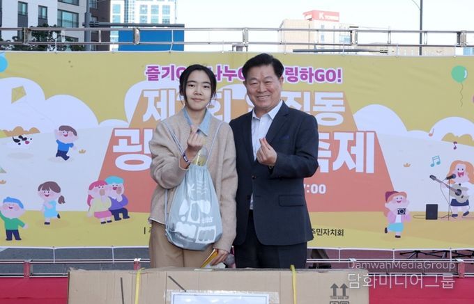 박승원 광명시장이 지난 1일 일직동 새빛공원로 차 없는 거리에서 열린 ‘제3회 일직동 광명새빛축제’에 참석해 상품을 전달하고 기념사진을 촬영하고 있다,