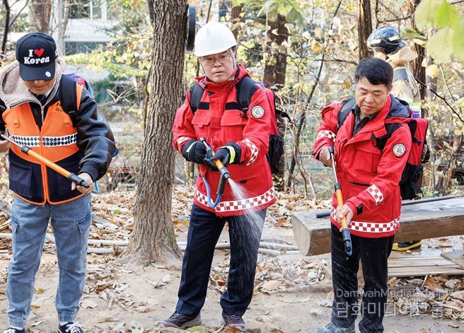진교훈 서울 강서구청장(가운데)이 21일 오후 우장산 일대에서 열린 ‘유관기관 합동 산불진압훈련’에서 등짐펌프를 매고 산불진화대원과 함께 잔불진화작업을 하고 있다.