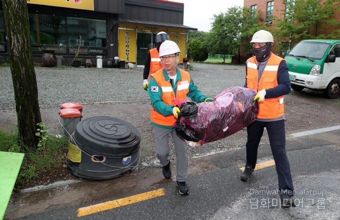 병규 광산구청장이 생활폐기물 수거 현장을 찾아 환경직 노동자들과 종량제 봉투를 나르고 있는 모습.