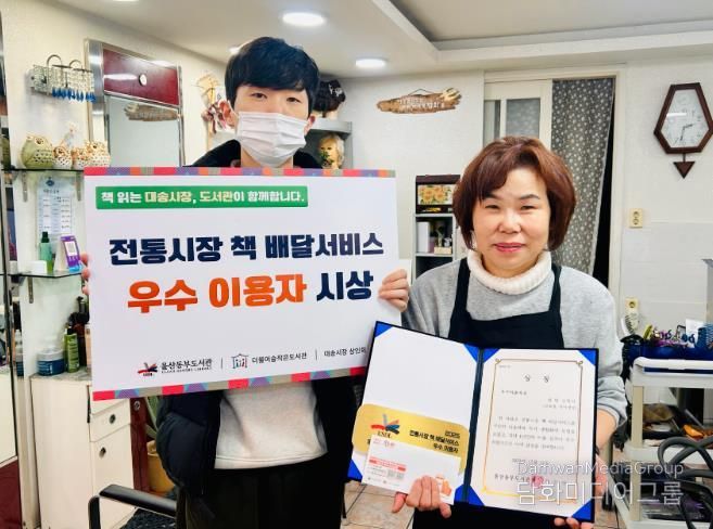 대송시장 헤어세상 심영미 사장이 동부도서관이 주관한 '전통시장 책 배달 프로그램' 우수이용자상을 받고 기념사진을 찍고있다