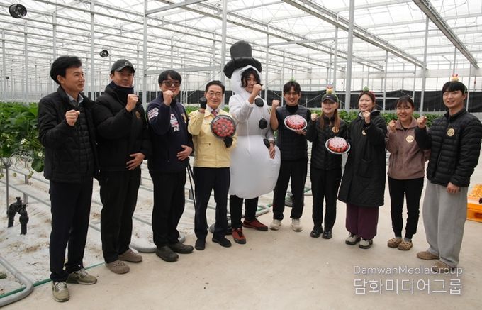 딸기 수확 현장에서 청년 농업인들과 시 관계자들이 기념 촬영을 하고 있다.