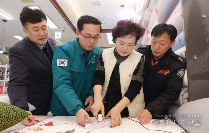 박희조 동구청장이 인동시장 상점가 전기 콘센트에 자동소화패치를 설치하는 모습