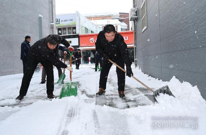 김산 군수와 공무원들이 무안읍 시가지에서 제설 작업을 하고 있다