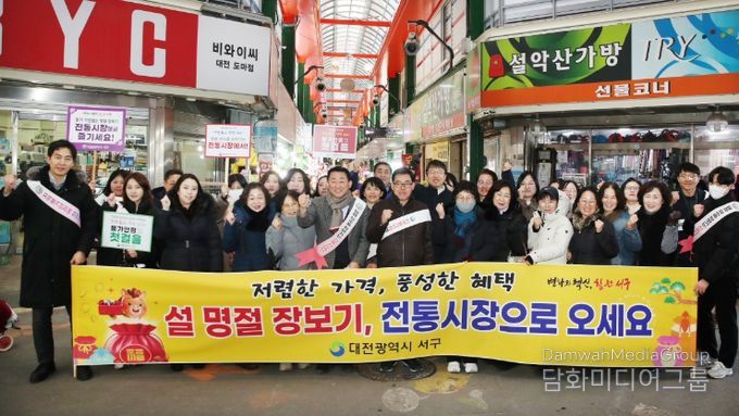 대전 서구 관계자들이 시장 상인에게 인사를 건네고 있다