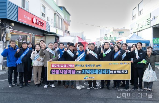 설맞이 전통시장 장보기·물가안정 캠페인을 전개한 참여자들이 단체 기념사진을 촬영하고 있다