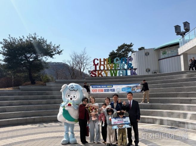 지난 22일 청양 칠갑타워에서 열린 10만 방문객 돌파 기념 이벤트에서 강희선 관광진흥과장(오른쪽 끝)이 10만 번째 방문객 임연옥 씨(왼쪽에서 다섯 번째)에게 기념품을 전달한 뒤 기념 촬영을 하고 있다.