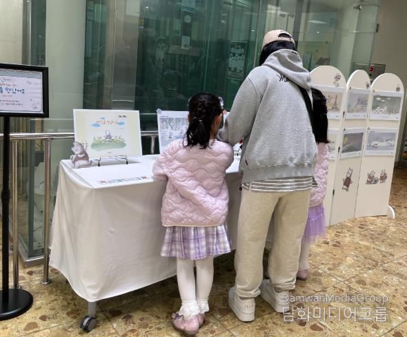 송정다가치문화도서관을 찾은 어린이와 시민들이 지난 3월 28일 도서관 1층 로비에 마련된 ‘열린 시선과 새로운 만남’ 그림책 원화 전시를 관람하고 있다.