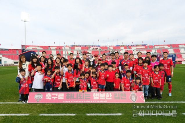 4월 12일 7R 안양전 홈경기에서 김천상무 선수들과 플레이어 에스코트 참가자들이 단체사진을 찍고 있다.